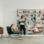 Psycholog prowadzi zajęcia z dziećmi między regałami nowoczesnej biblioteki