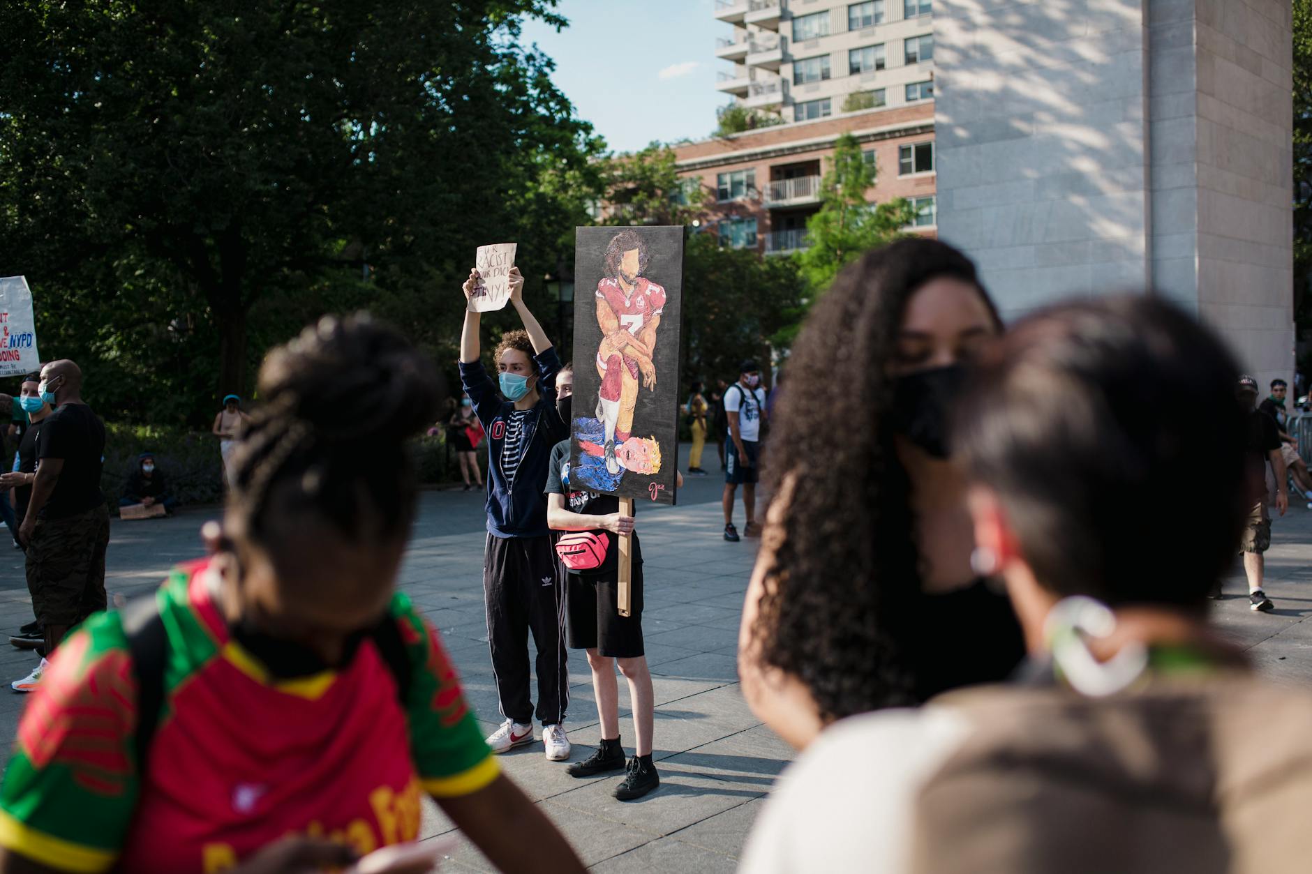 Pokojowa demonstracja w miejskim parku, ludzie z transparentami