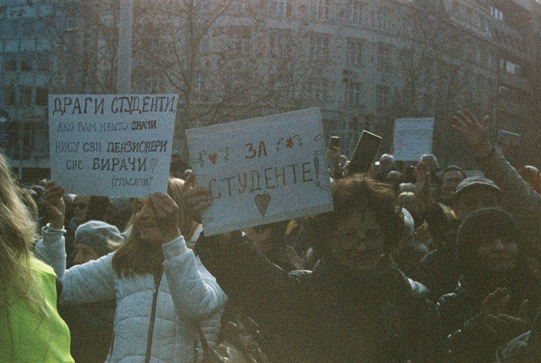 Studenci na pokojowej demonstracji z transparentami na zewnątrz